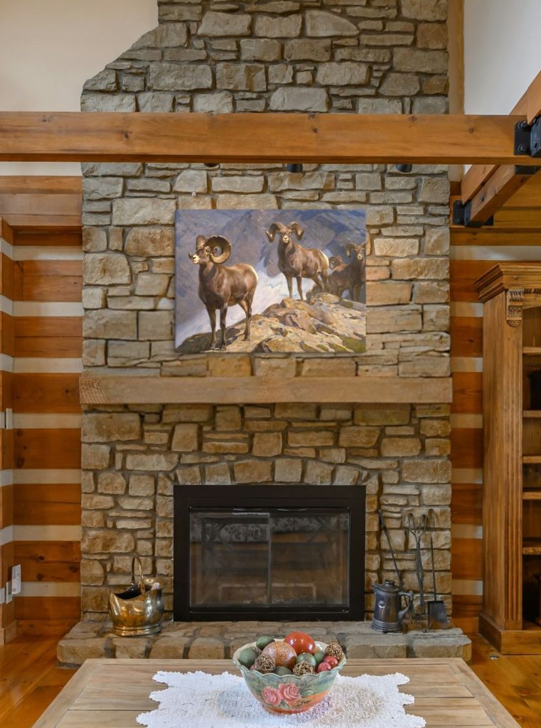 Antique print of big horn sheep canvas wall art hanging above a fireplace